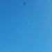 Xpece Rescue Drone flying with a suspended payload on a tether against blue sky